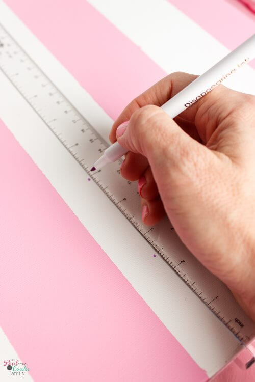 using disappearing ink marker to make marks for opposite direction stripes Step by step tutorial on how to paint gingham and make the cutest wall art out of a craft store canvas. Perfect craft project to make DIY wall art.